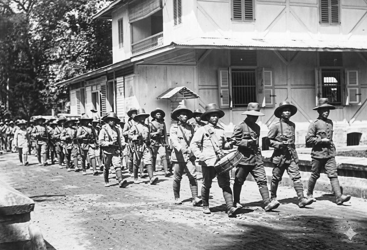 Barisan pasukan KNIL asal Minahasa berbaris rapi melintasi kawasan Kantor Pos Manado (Repro Koleksi Nederlands Instituut voor Militaire Historie - NIMH 1918)