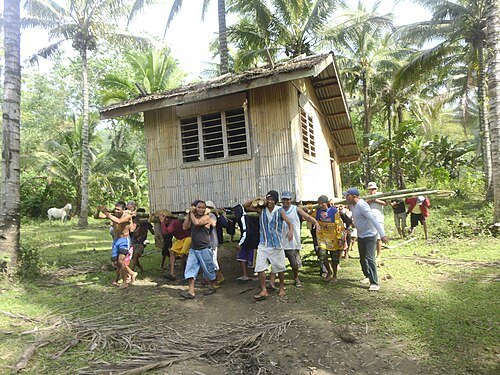 Anggota komuintas "bayanihan" di Filipina bergotong royong memindahkan rumah ke lokasi baru (wikipedia)